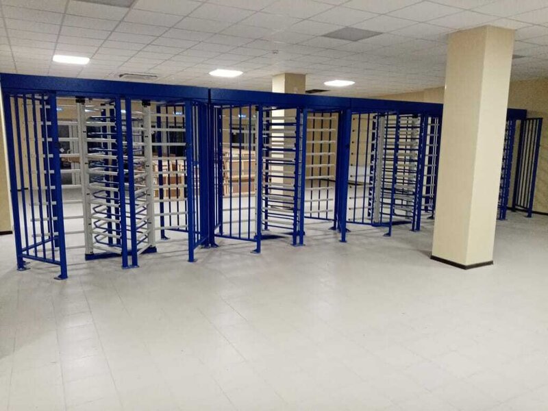Ряд полноростовых турникетов на контрольно-пропускном пункте склада