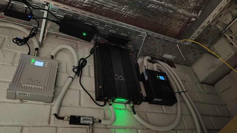 Репитер и блок питания системы усиления сотовой связи под потолком паркинга