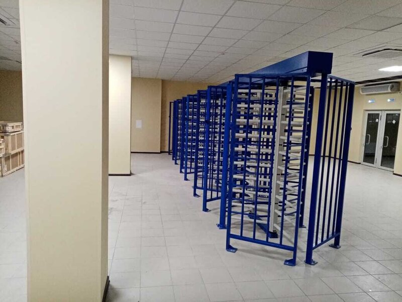 Полноростовые роторные турникеты в синем корпусе в помещении КПП